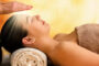 Midsection of therapist performing reiki treatment on woman at spa