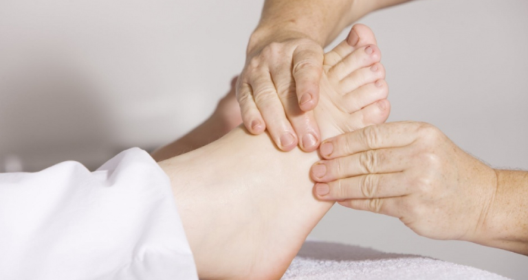 A Woman Experiencing Feet Massage Therapy.