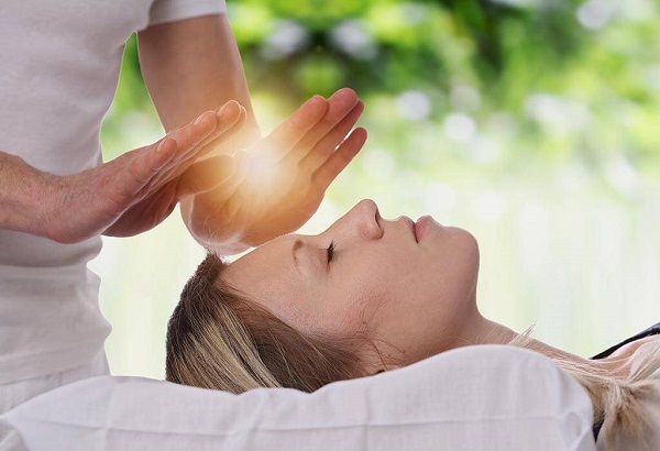 A Reiki Specialist Giving Healing Therapy To A Young Woman.