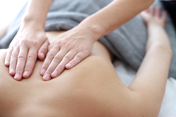 A Woman Therapist Giving Massage For A Male Patient.