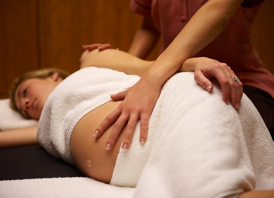 A Side View of Pregnancy Woman Getting Reiki Massage.