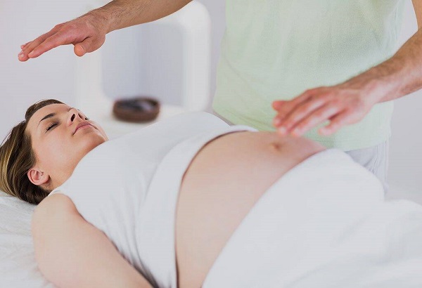 A Reiki Massage Therapist Giving Healing Therapy To A Pregnant Lady.