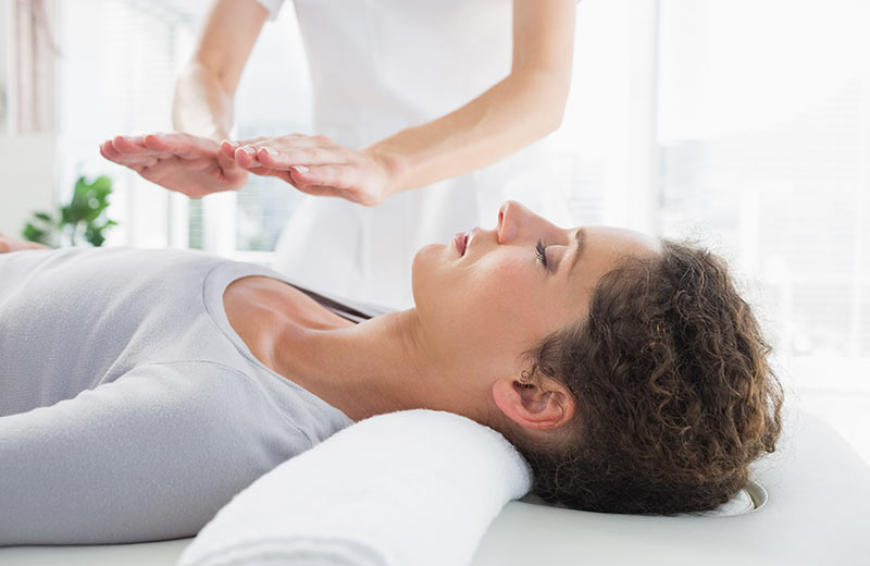 A Woman getting Relaxed During Her Reiki Session.