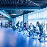 The inside of a fitness center with people exercising.