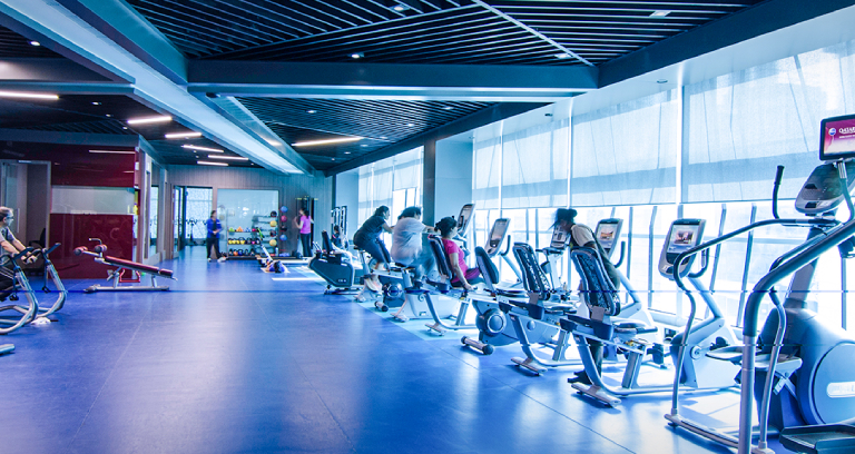 The inside of a fitness center with people exercising.