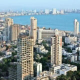 Rows of high rise buildings by the side of the sea.